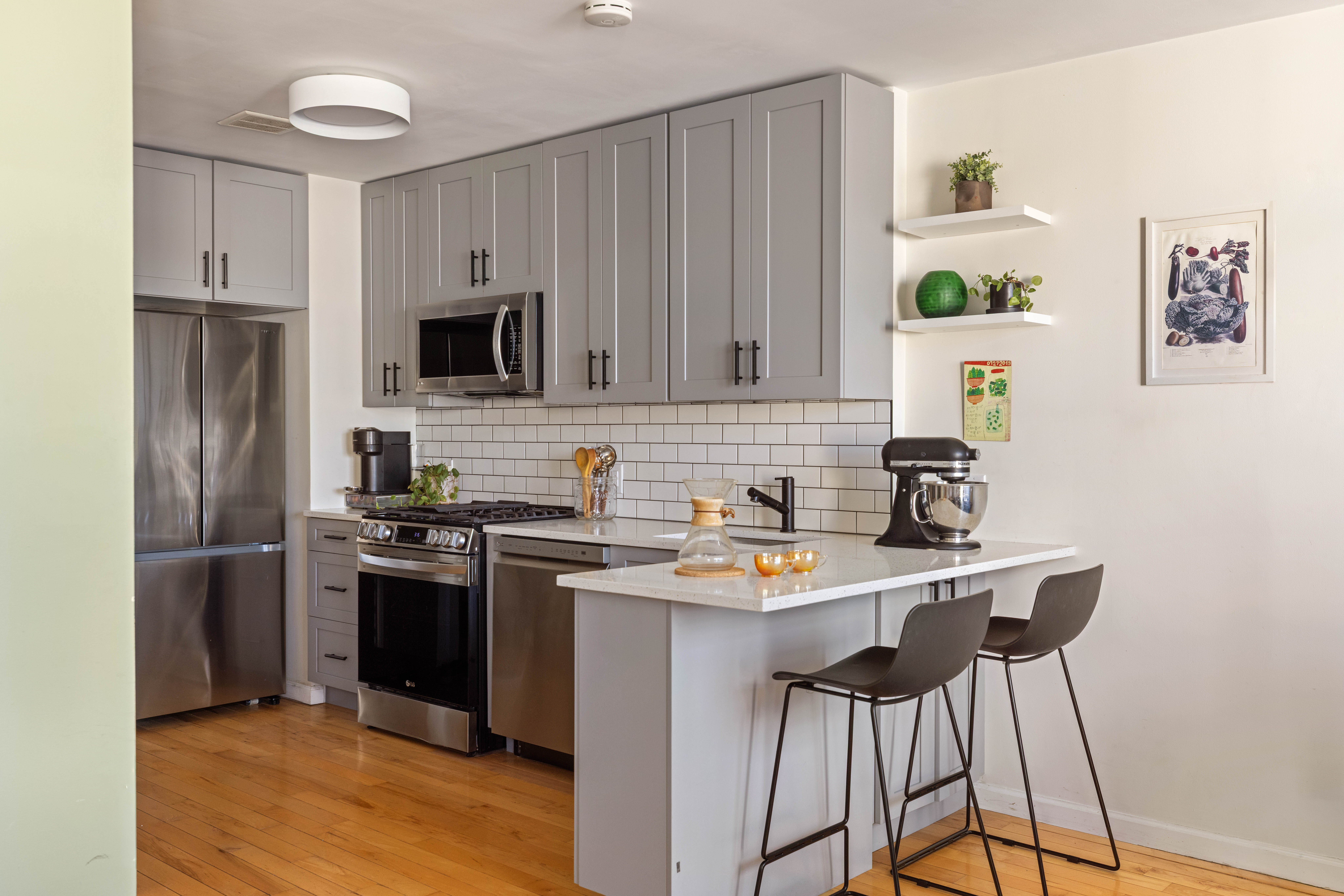 93-95 Wyckoff Avenue, Unit 4B Brooklyn, NY 11237 - Photo 4 of 10 a kitchen with stainless steel appliances a stove a sink refrigerator and a microwave