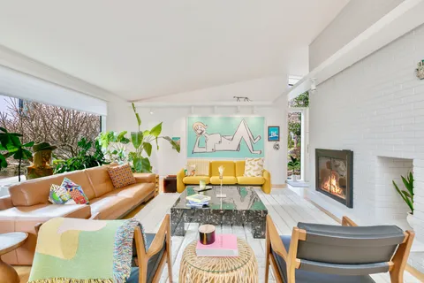 a living room with fireplace furniture and a large window