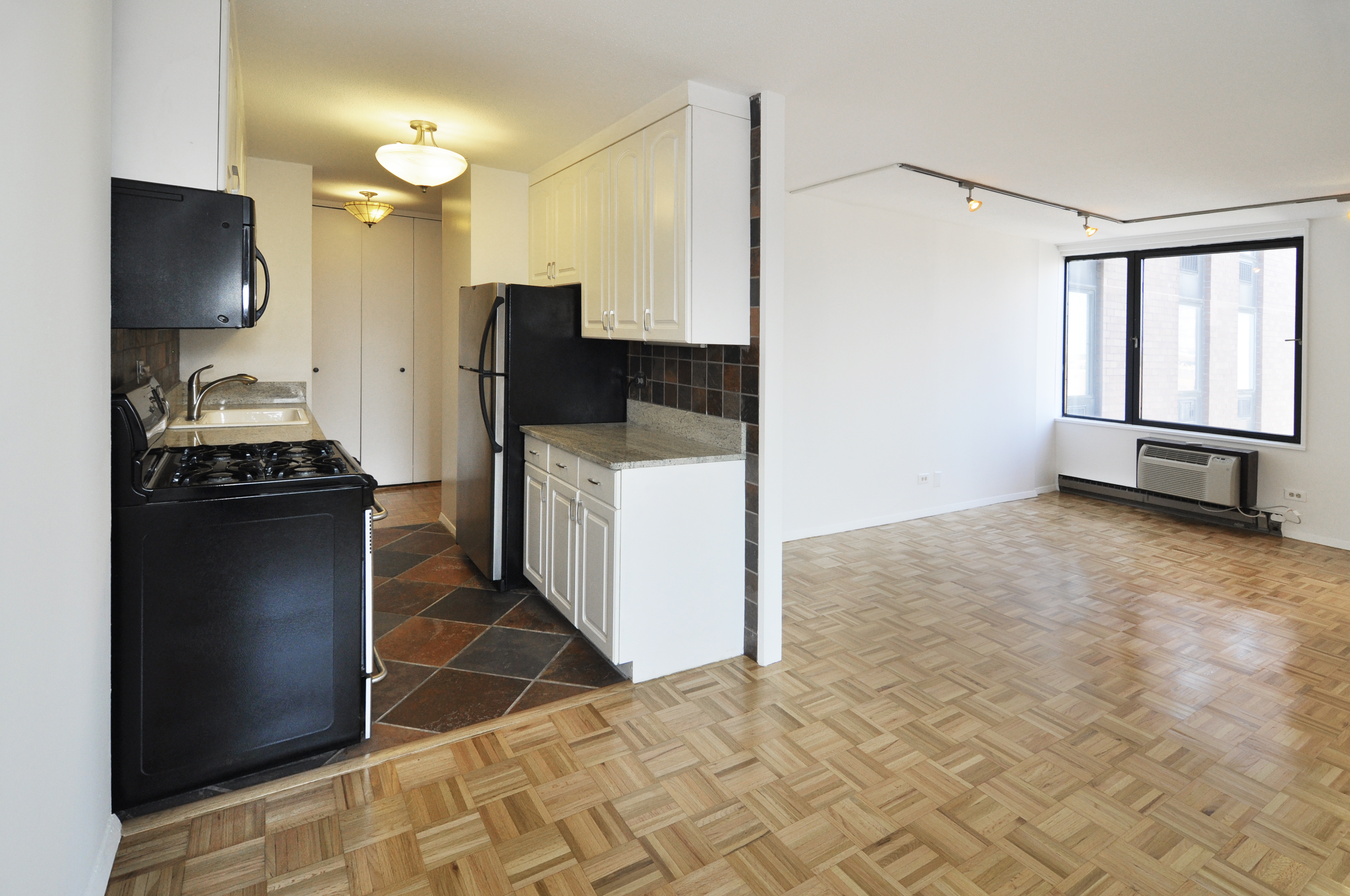1623 3rd Avenue, Unit 25C Manhattan, NY 10128 - Photo 3 of 12 a kitchen with granite countertop a refrigerator and a stove