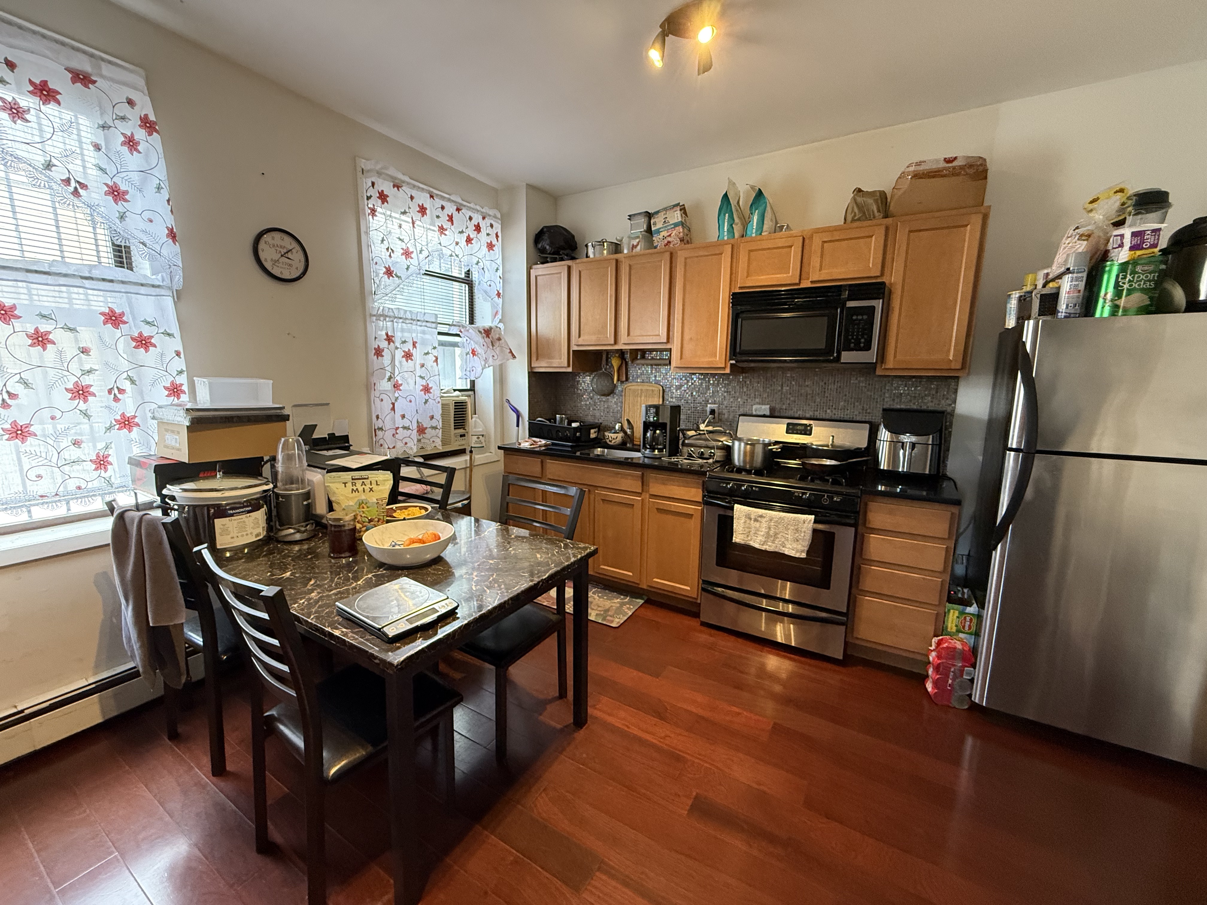 599 60th Street West New York, NJ 07093 - Photo 15 of 17 a living room with stainless steel appliances furniture a flat screen tv and a refrigerator