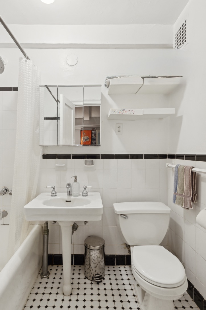235 West 102nd Street, Unit 8A Manhattan, NY 10025 - Photo 4 of 5 a white toilet sitting next to a bathroom sink