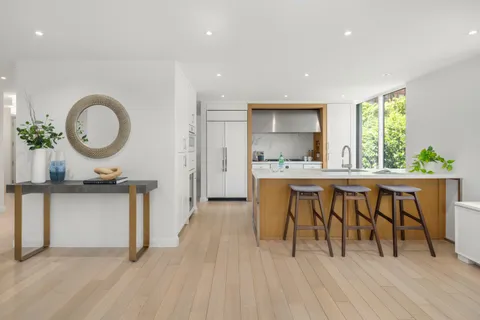 a living room with granite countertop kitchen island a furniture a stove a sink and a large window