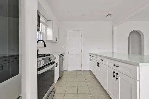 a kitchen with granite countertop a stove and a refrigerator