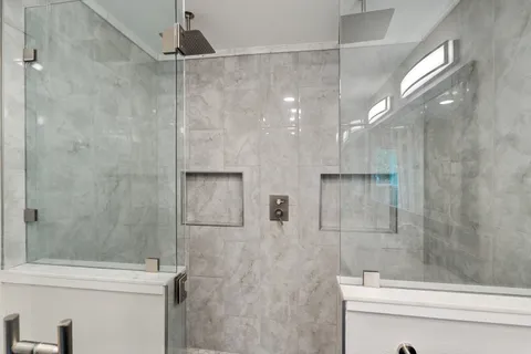 a bathroom with a granite countertop sink toilet and shower