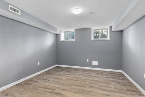 a view of an empty room with wooden floor and closet