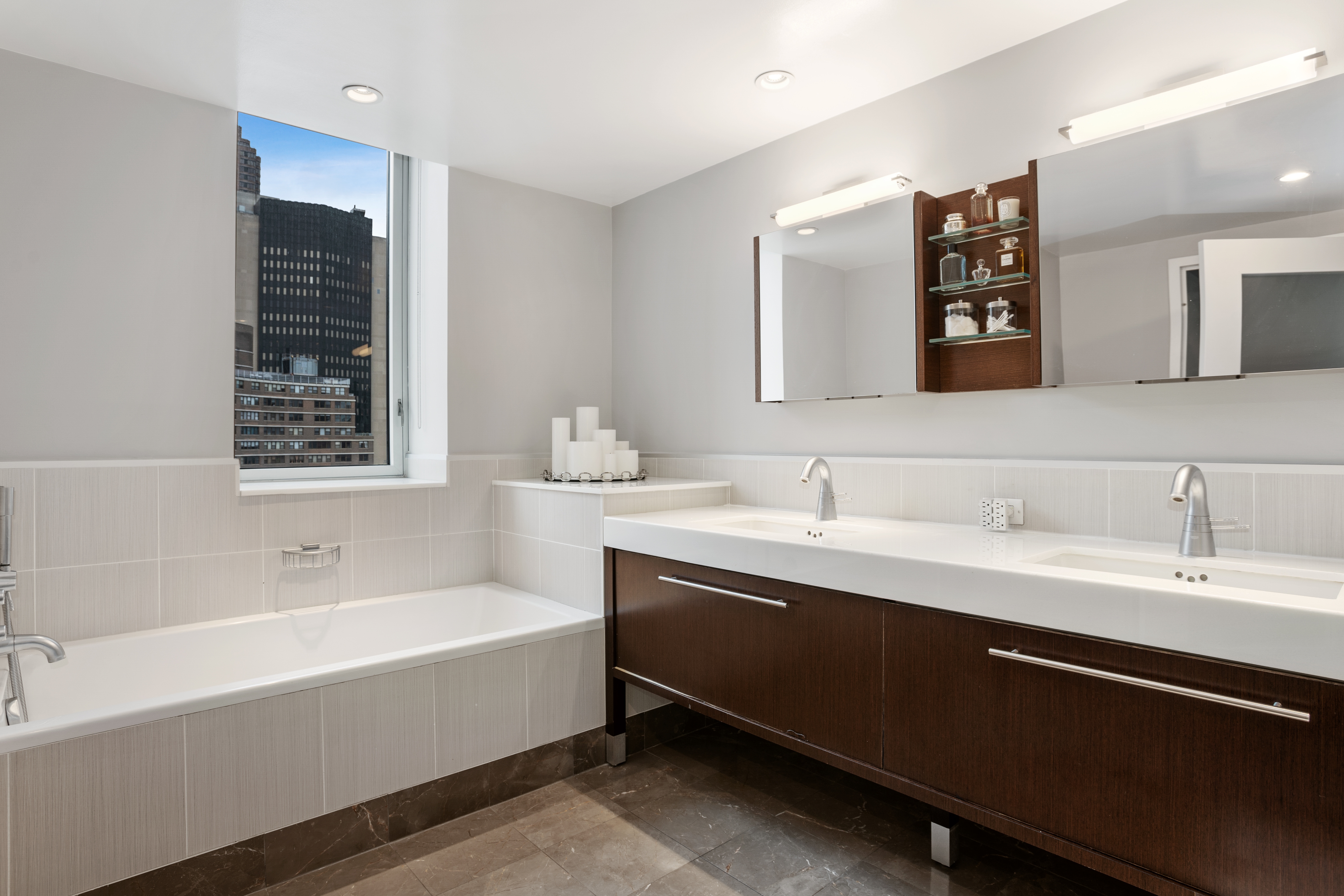 225 East 34th Street, Unit 17C Manhattan, NY 10016 - Photo 5 of 19 a bathroom with a bathtub sink and mirror