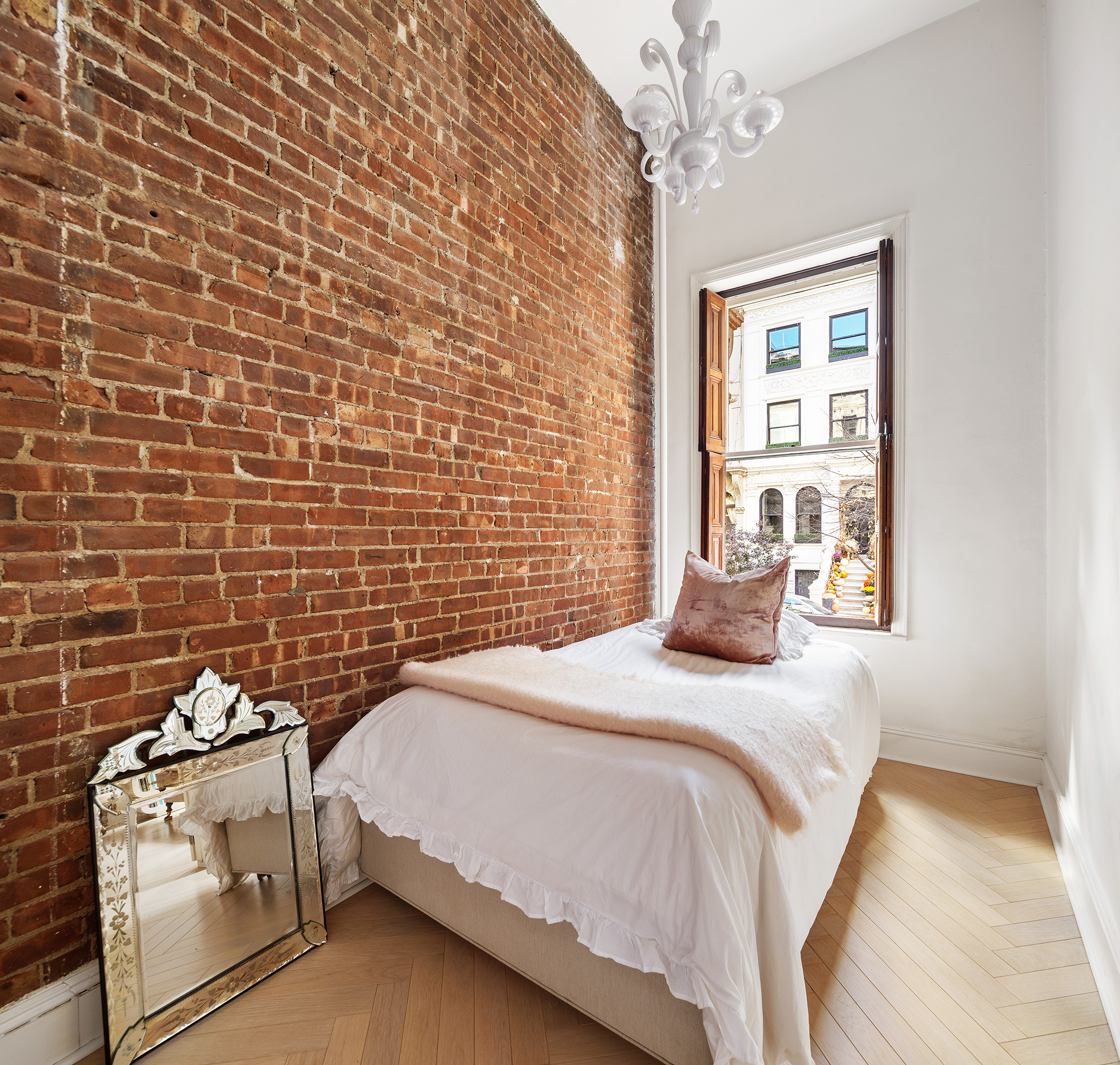 133 West 75th Street, Unit PARLOUR A Manhattan, NY 10023 - Photo 8 of 11 a bedroom with a bed and a chandelier