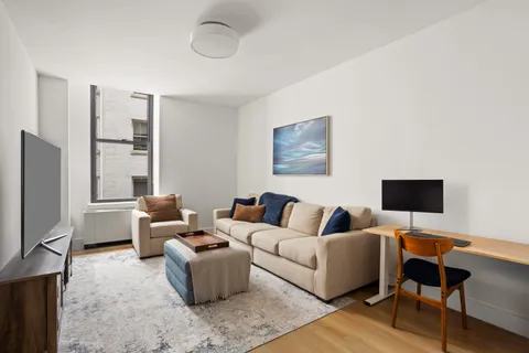 a living room with furniture wooden floor and a flat screen tv