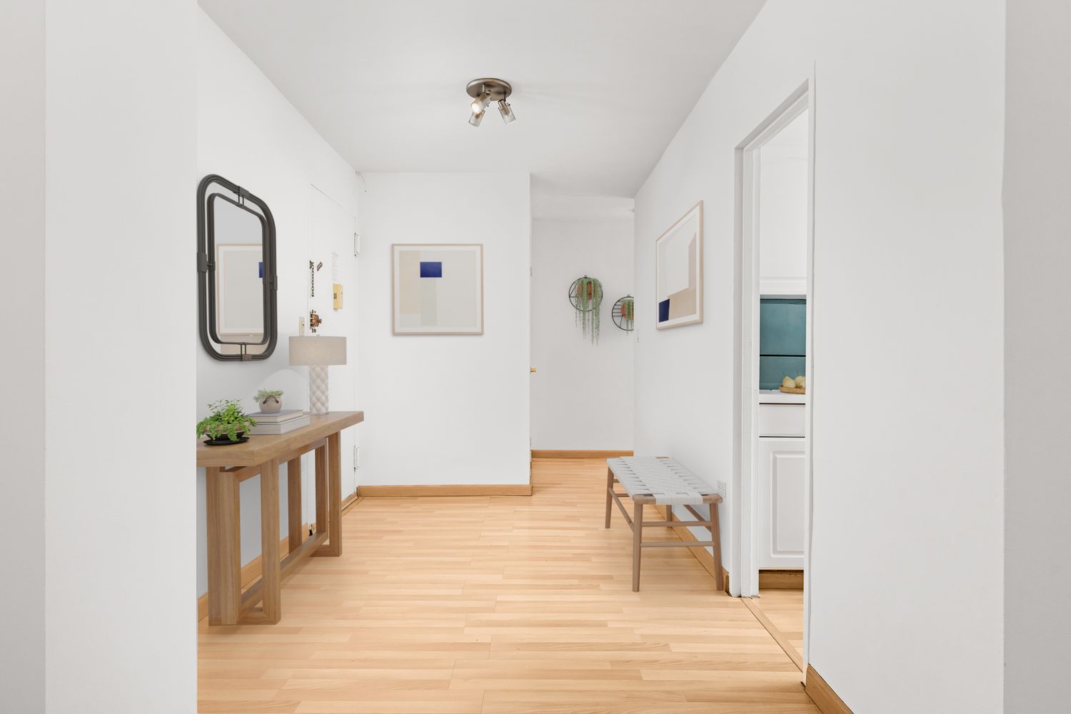 a view of a hallway with wooden floor and furniture