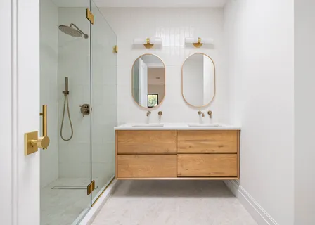 a bathroom with a double vanity sink mirror and shower