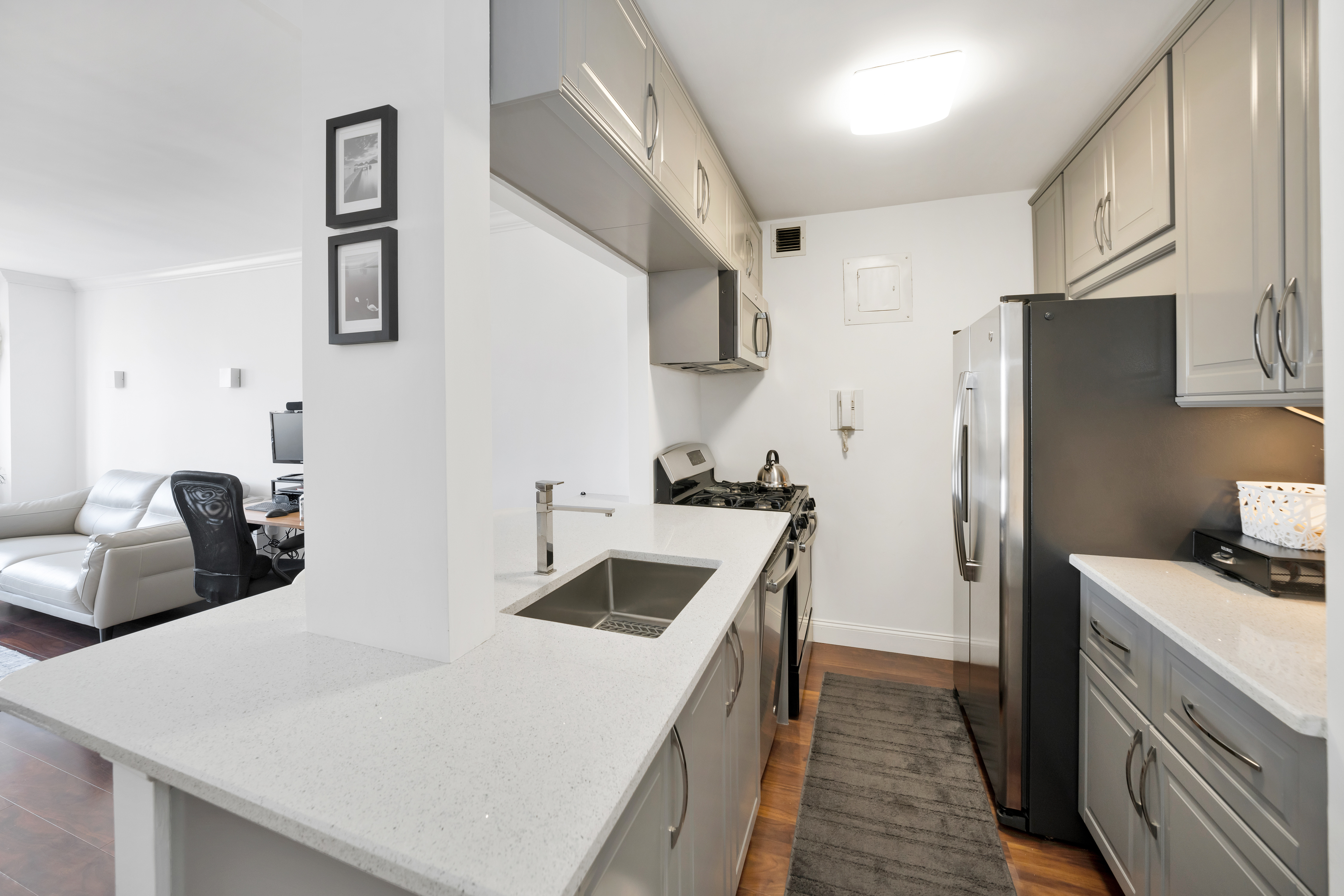400 East 54th Street, Unit 26D Manhattan, NY 10022 - Photo 4 of 12 a kitchen with stainless steel appliances a sink and a refrigerator