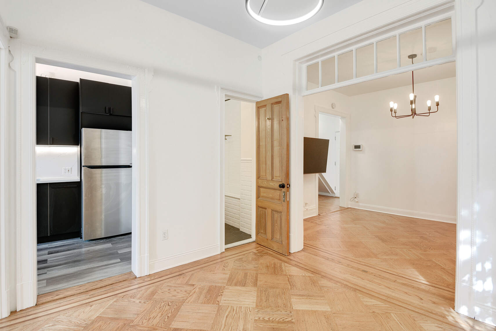 514 Hart Street, Unit PARLOR Brooklyn, NY 11221 - Photo 1 of 9 a view of a hallway with wooden floor and chandelier