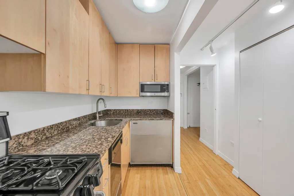 a kitchen with a stove and a wooden floor