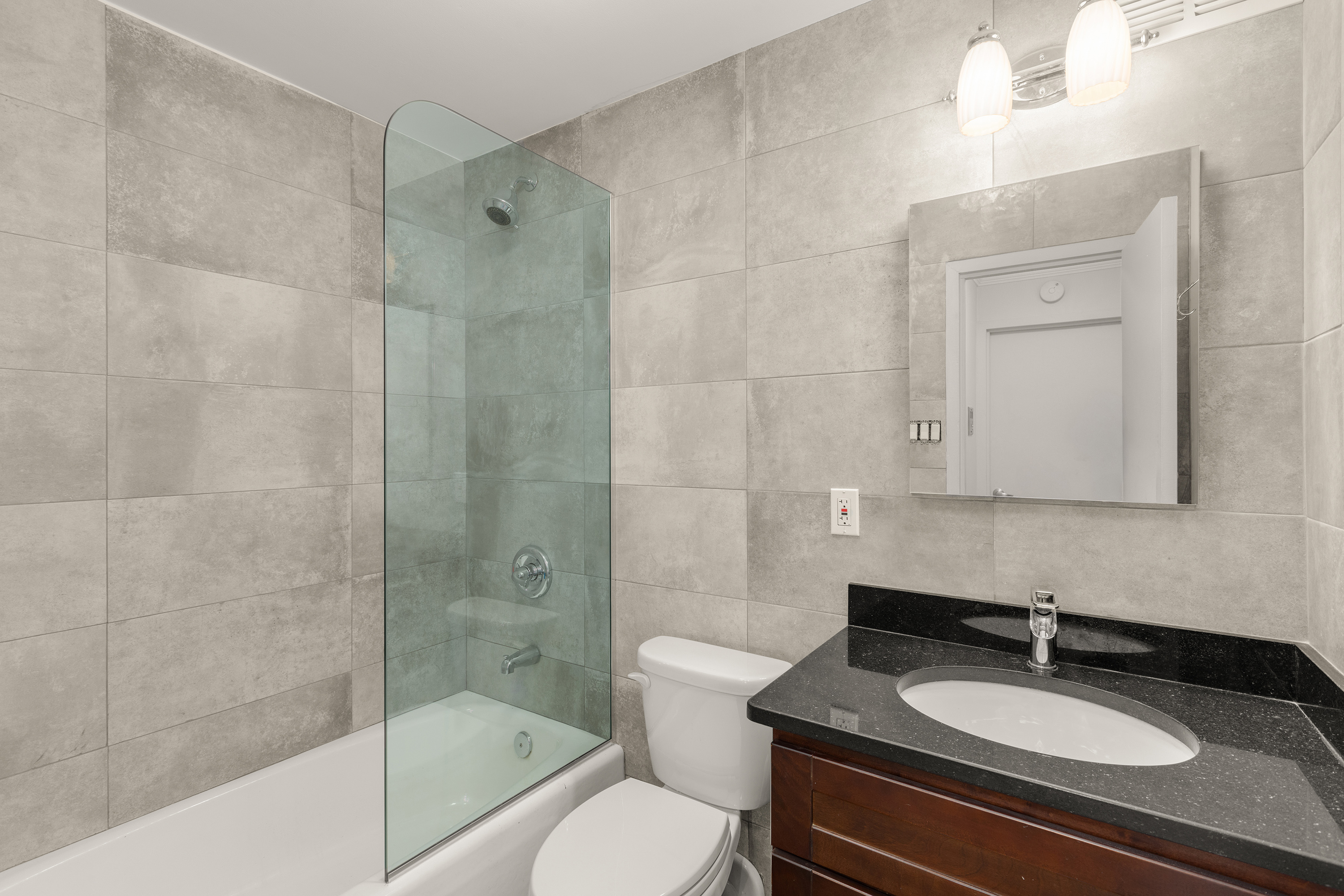 7 East 35th Street, Unit 2E Manhattan, NY 10016 - Photo 7 of 10 a bathroom with a sink toilet a mirror and shower