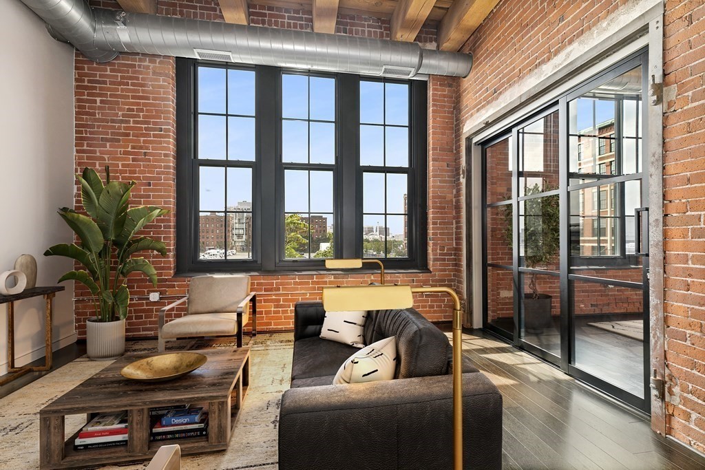 319 A Street, Unit 211 Boston, MA 02210 - Photo 5 of 24 a living room with furniture and a floor to ceiling window