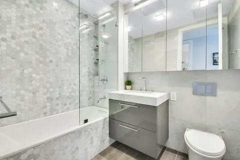 a bathroom with a sink toilet vanity and shower