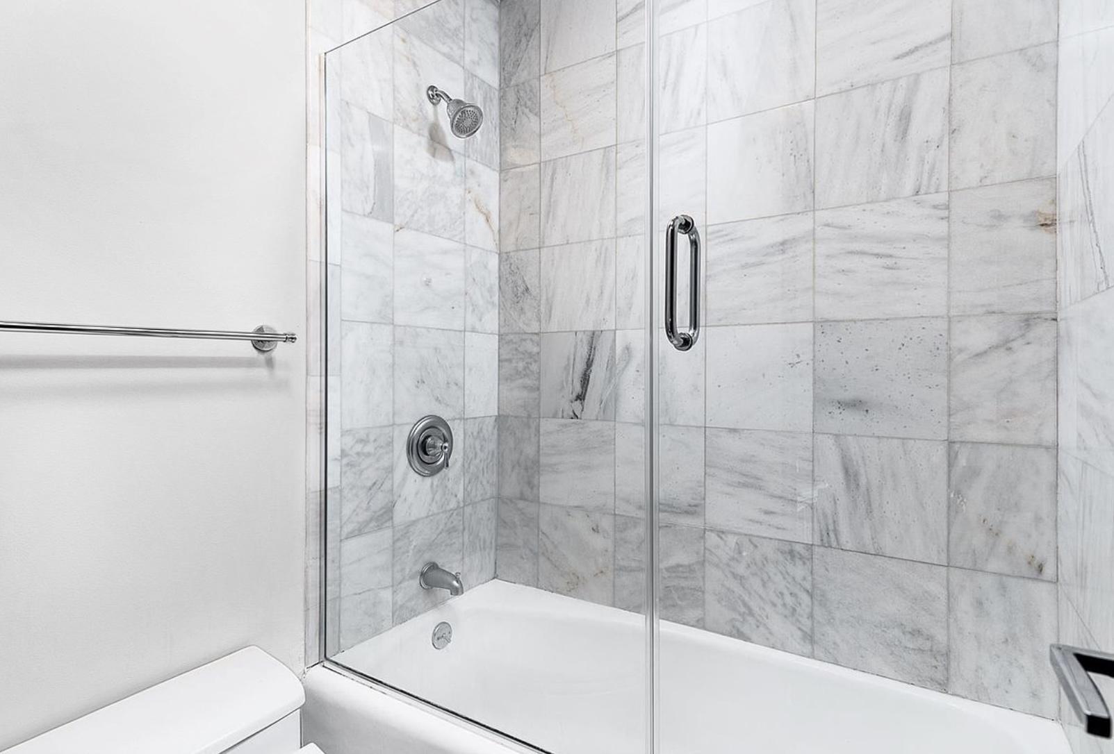 117 East 57th Street, Unit 48G Manhattan, NY 10022 - Photo 5 of 13 a white bath tub sitting next to a shower