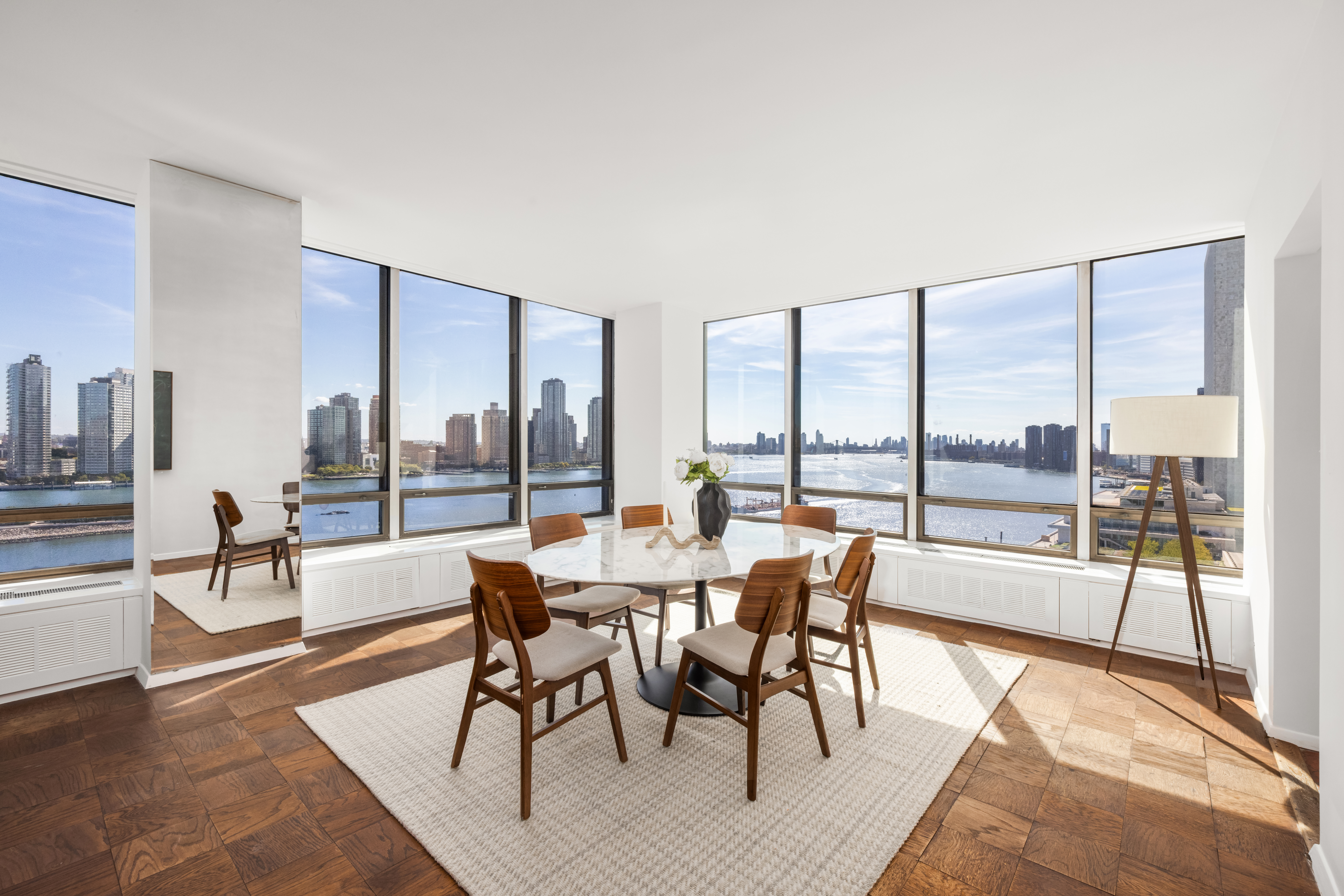 870 United Nations Plaza, Unit 14F Manhattan, NY 10017 - Photo 3 of 16 a dining room with furniture and wooden floor