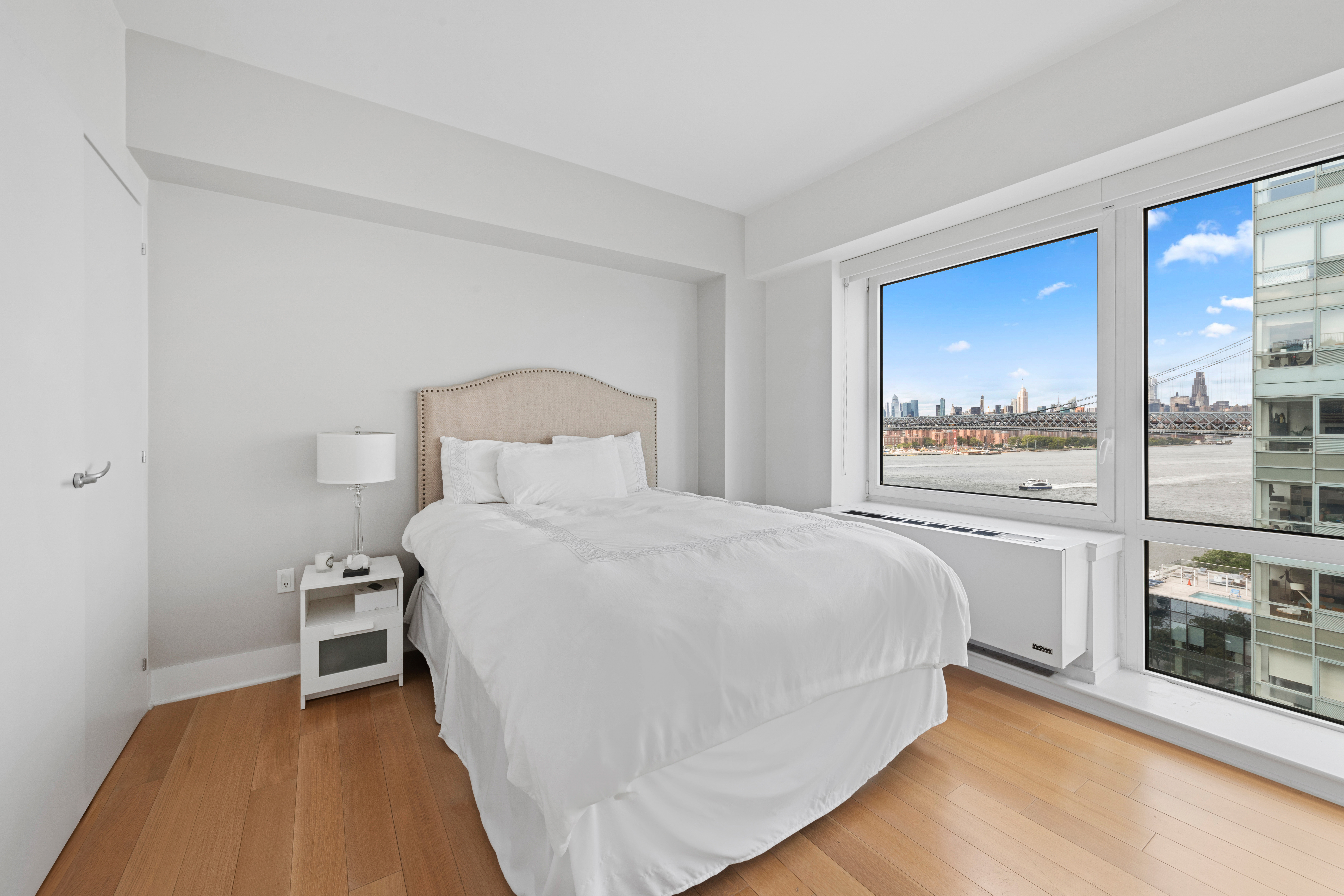 446 Kent Avenue, Unit 14A Brooklyn, NY 11249 - Photo 14 of 19 a bedroom with a bed and large window