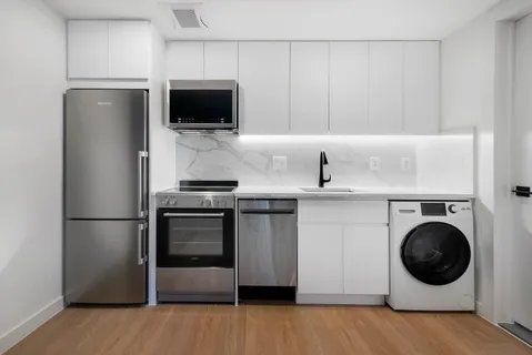 a kitchen with a refrigerator and a stove top oven
