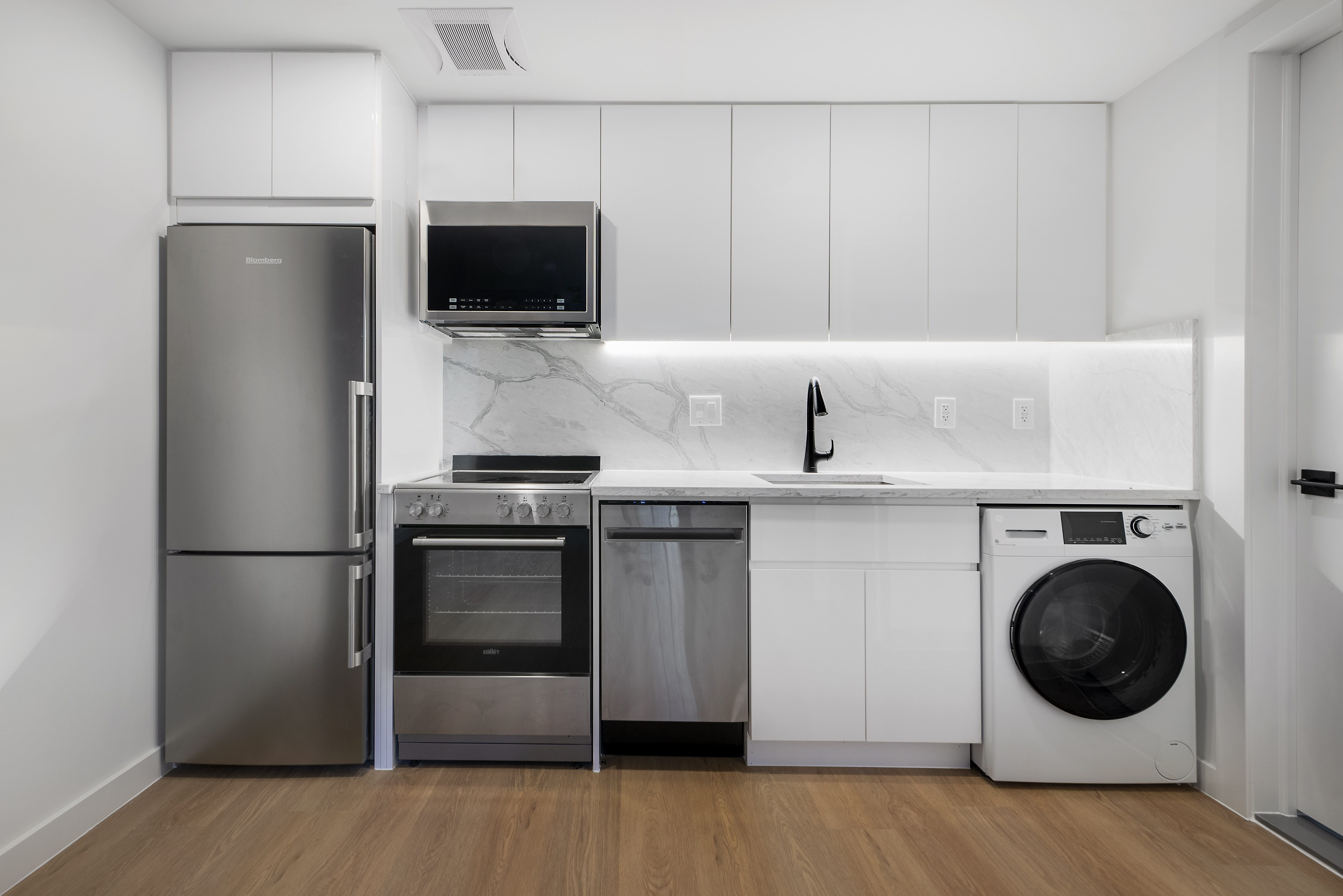 a kitchen with a refrigerator and a stove top oven
