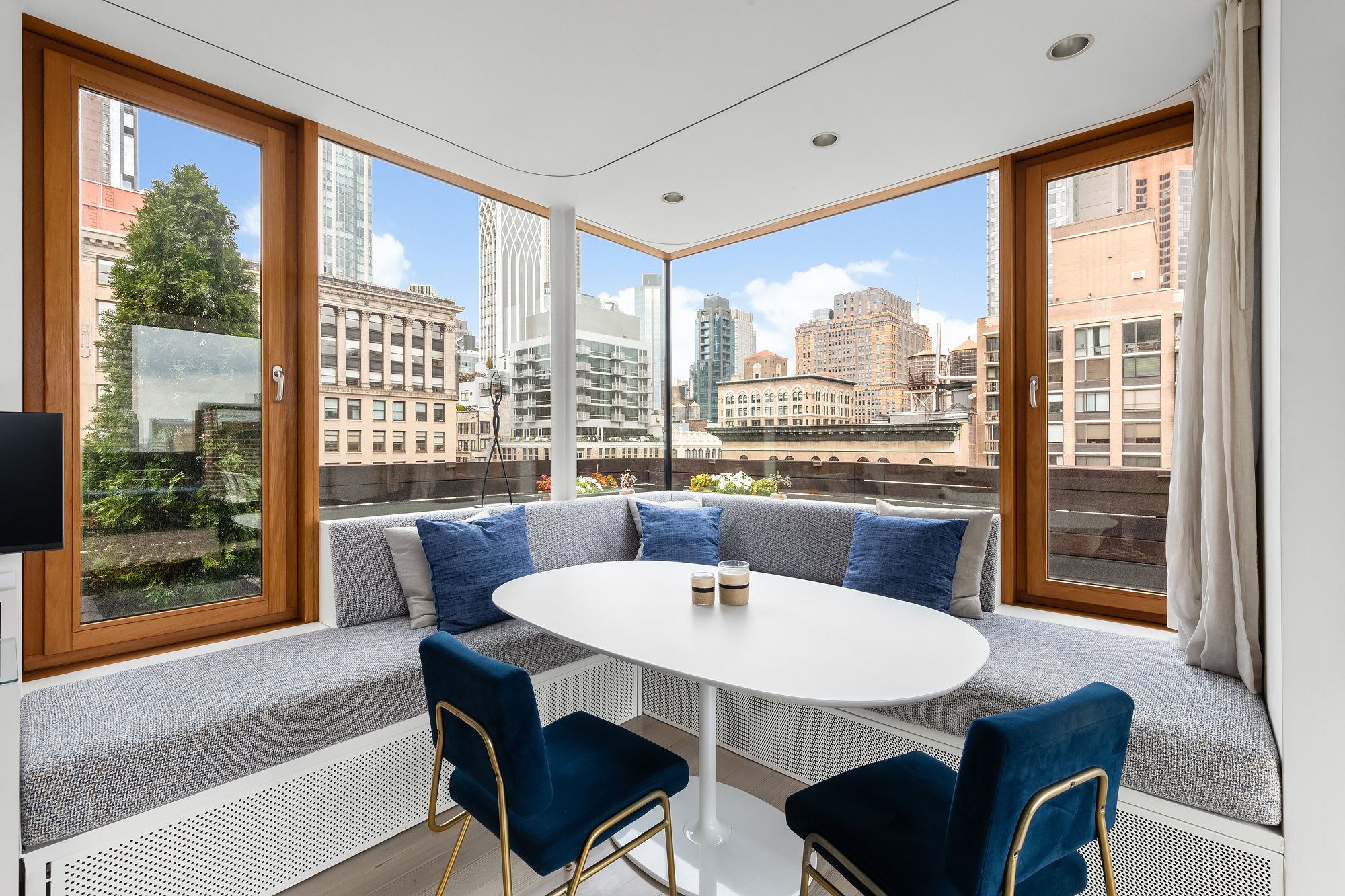 105 East 29th Street, Unit 12PH Manhattan, NY 10016 - Photo 18 of 24 a view of a dining room with furniture large windows and wooden floor