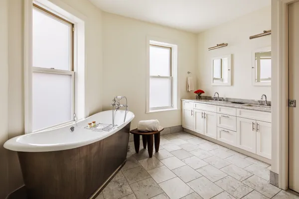a spacious bathroom with a double vanity sink a mirror and a bathtub