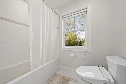 a living room with furniture a wooden floor and next to a window