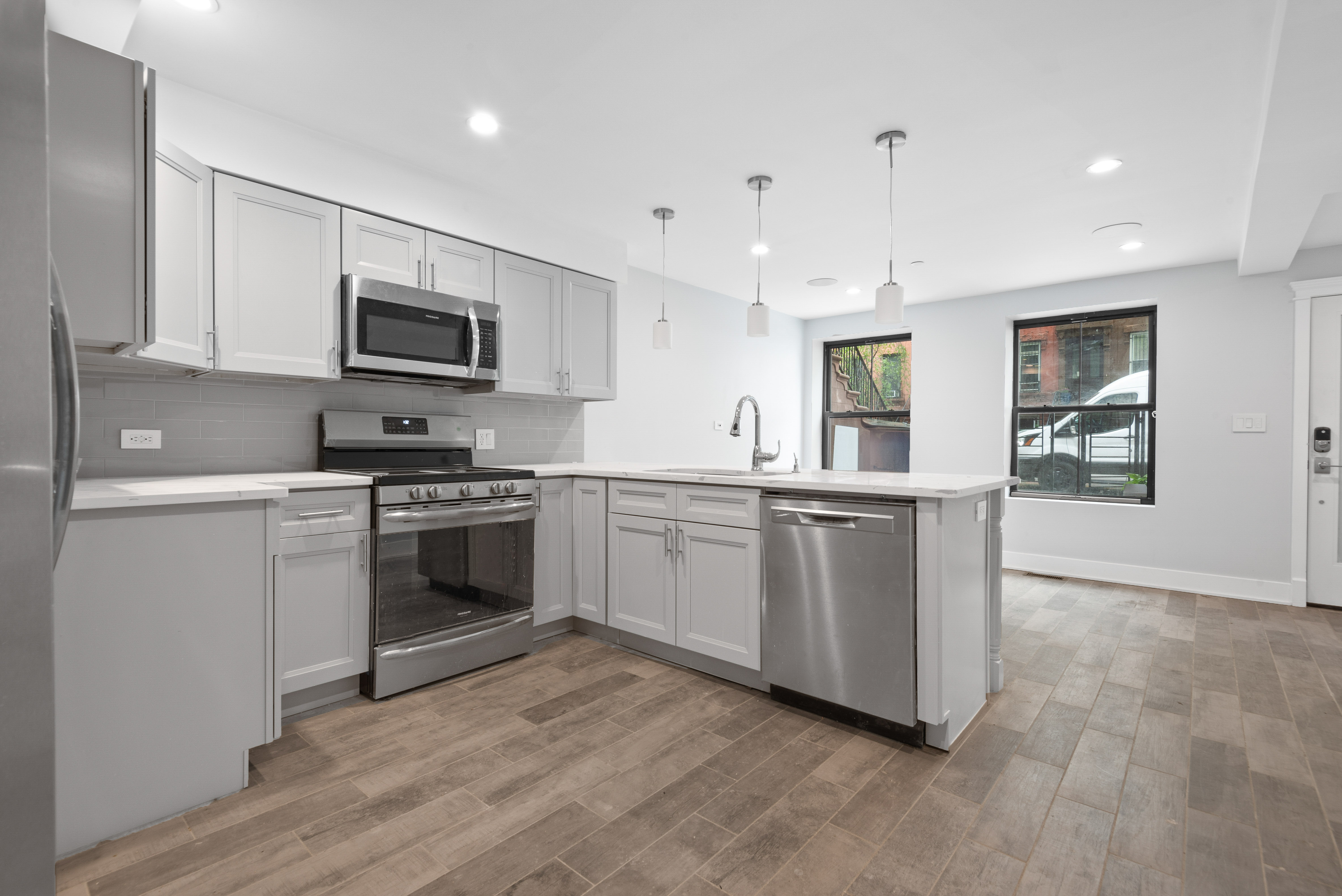 560 Hancock Street, Unit 2 Brooklyn, NY 11233 - Photo 2 of 6 a kitchen with white cabinets and stainless steel appliances
