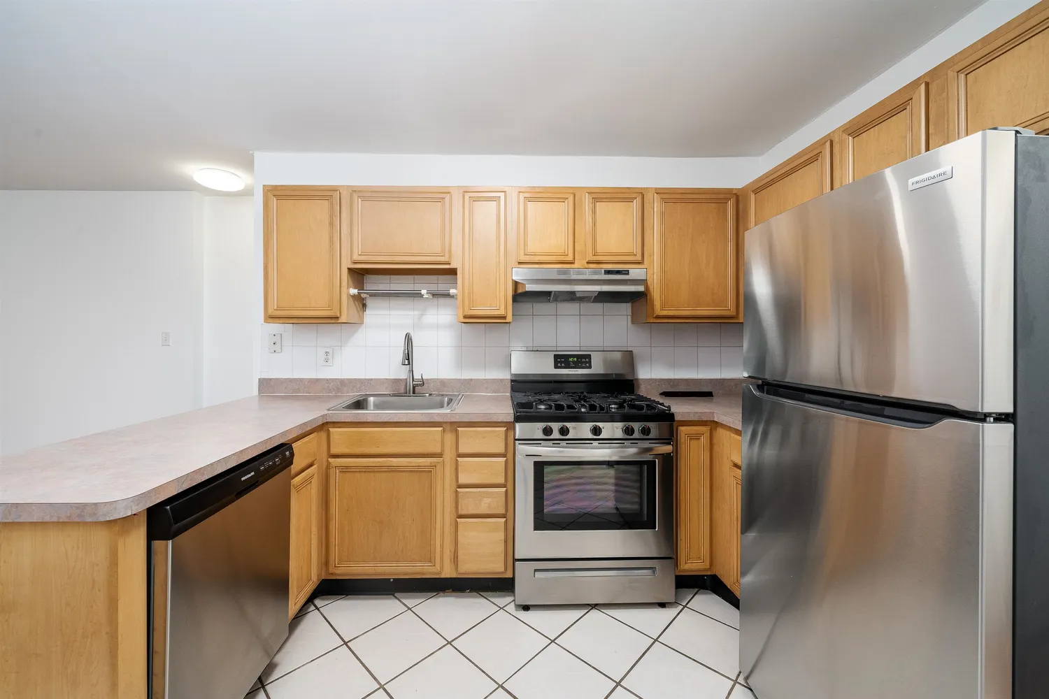 a kitchen with stainless steel appliances white cabinets and a refrigerator