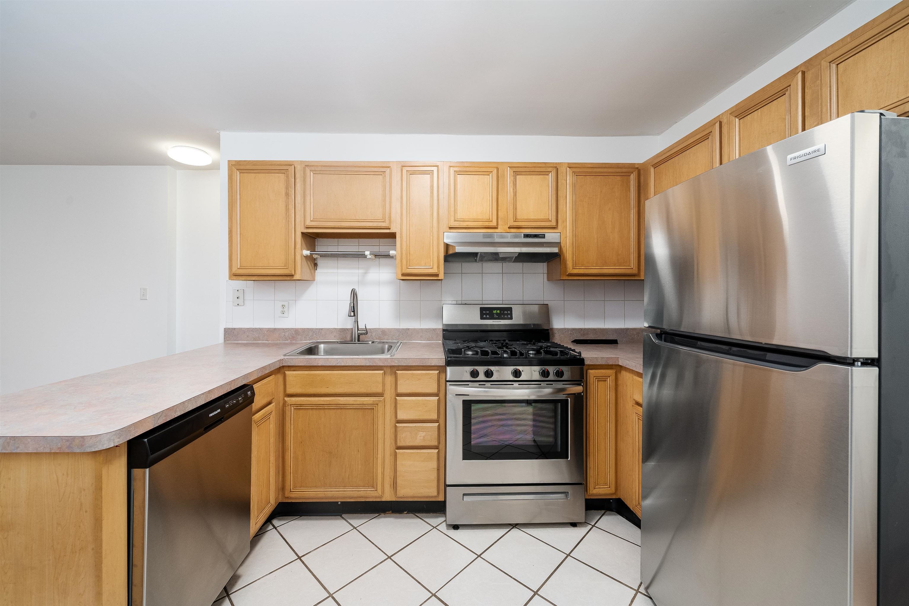 639 Garden Street, Unit 1 Hoboken, NJ 07030 - Photo 6 of 17 a kitchen with stainless steel appliances white cabinets and a refrigerator