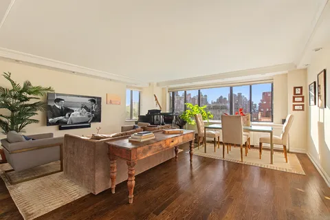 a living room with furniture a wooden floor and a large window