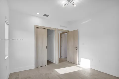 a view of a livingroom with a ceiling fan & entryway