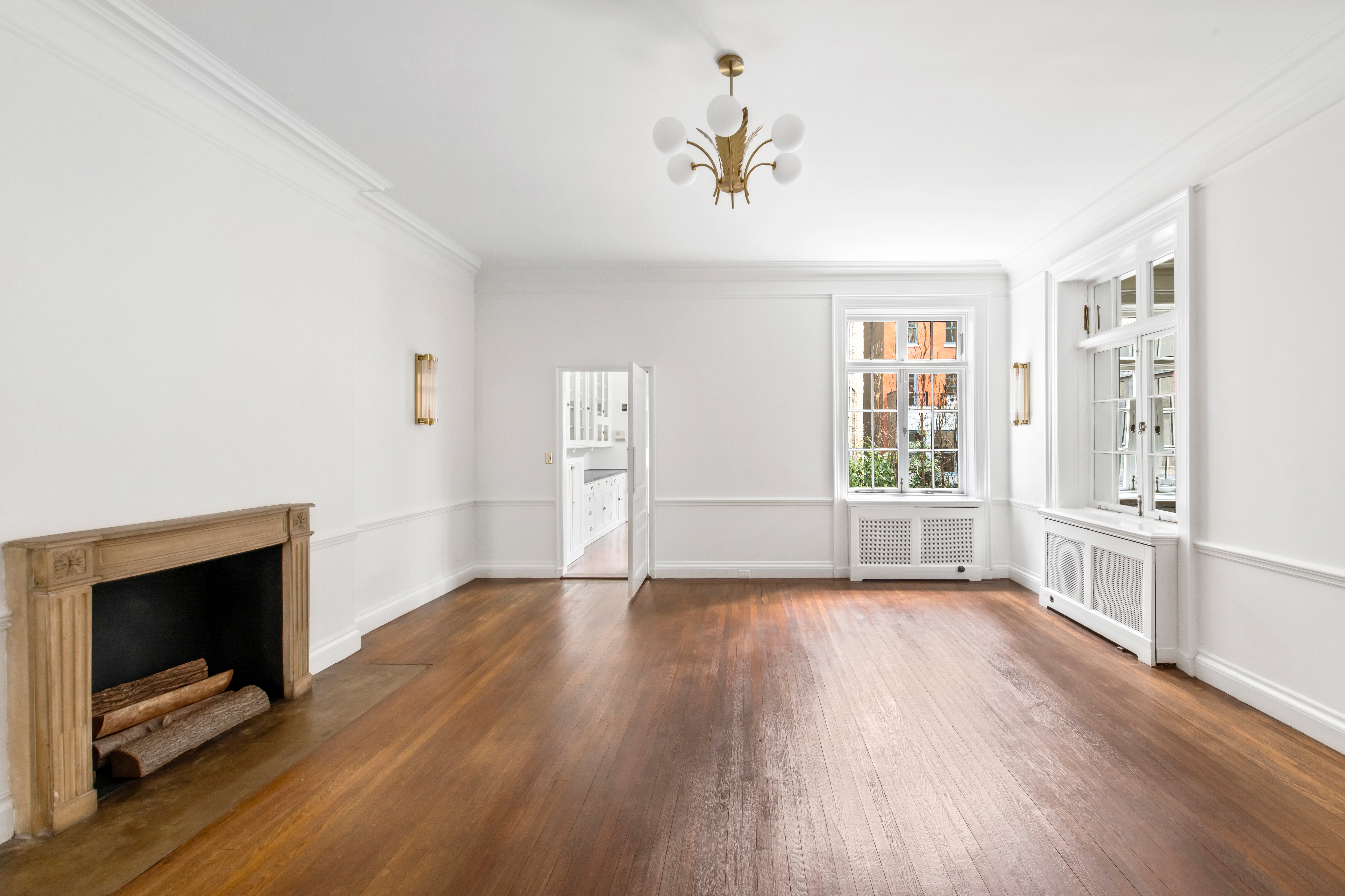 155 East 70th Street Manhattan, NY 10021 - Photo 9 of 27 an empty room with wooden floor fireplace and windows