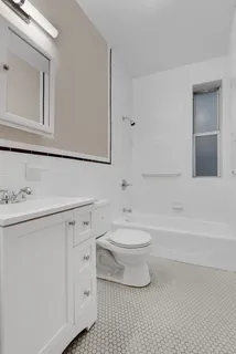 a bathroom with a toilet a sink a mirror and bathtub