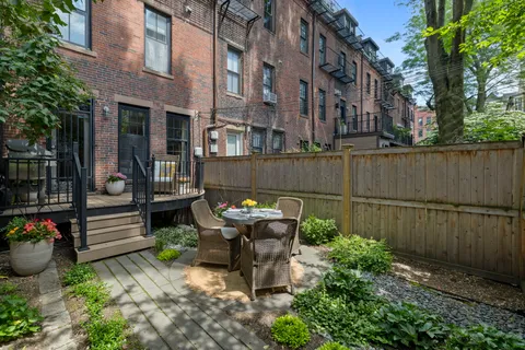 a view of a patio with table and chairs and potted plants