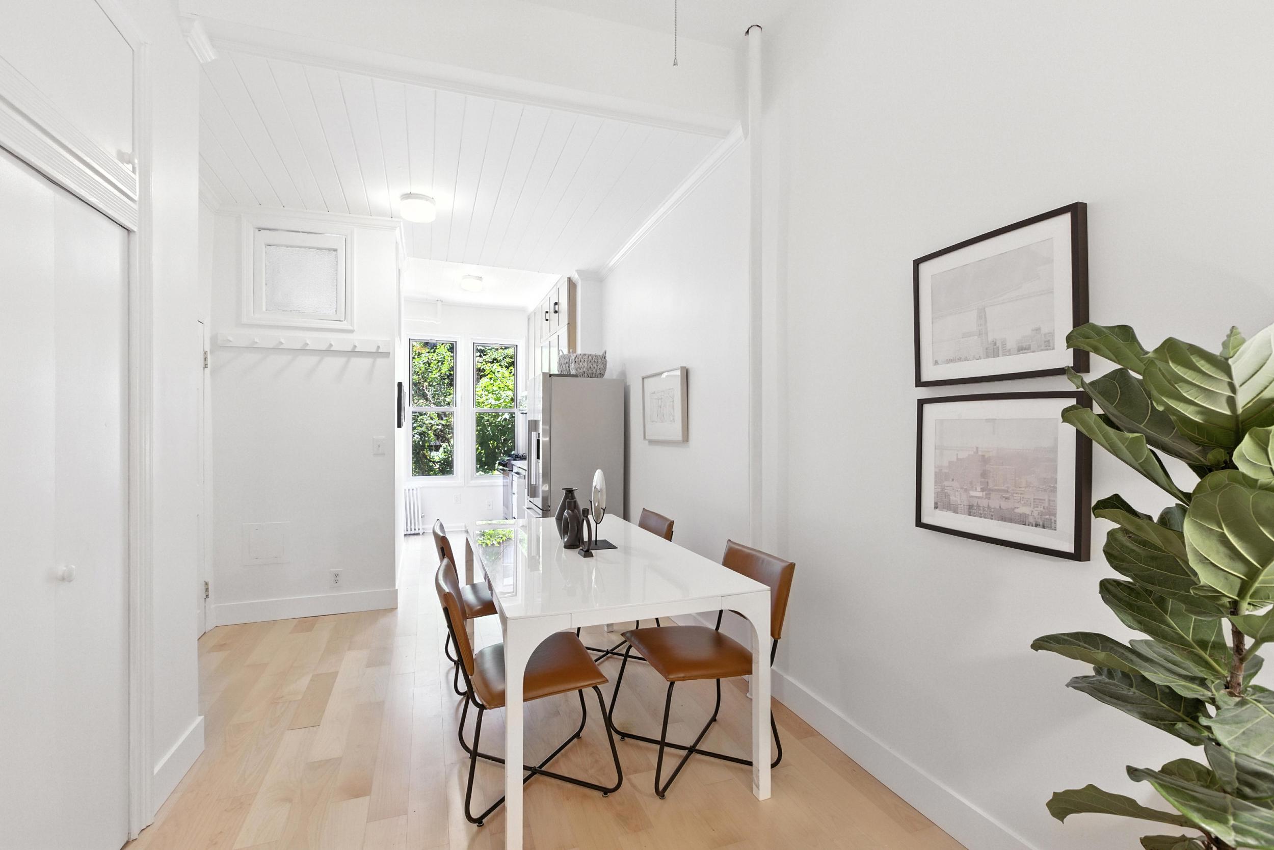 a dining room with furniture and a potted plant