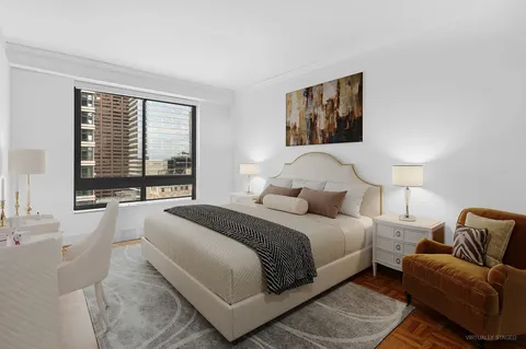 a bedroom with a bed couch and a large window