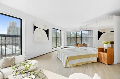 a spacious bedroom with a bed wooden floor and window