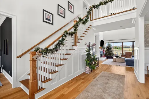 a living room with furniture a flat screen tv and a floor to ceiling window