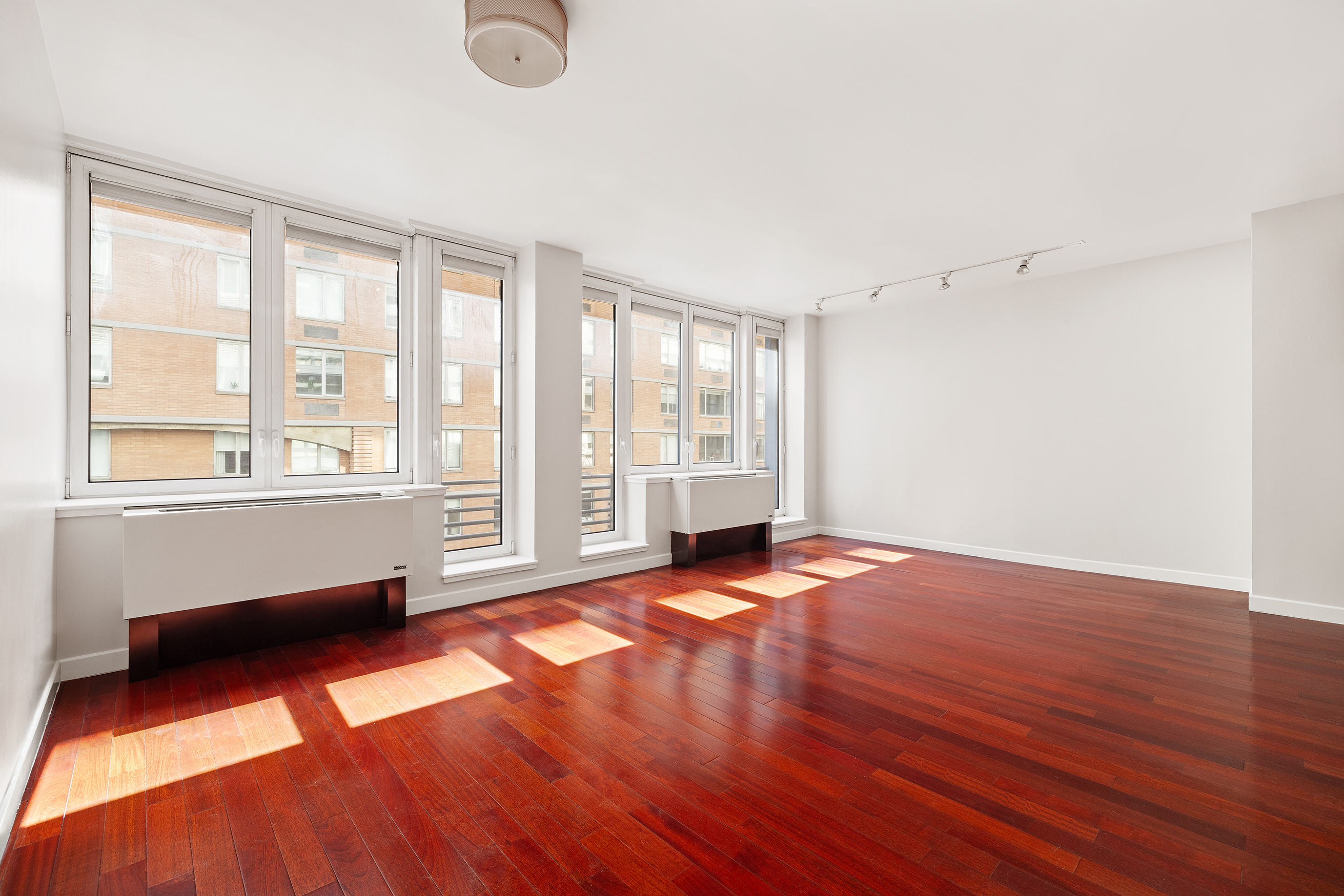125 West 21st Street, Unit 5B Manhattan, NY 10011 - Photo 2 of 15 an empty room with wooden floor and windows