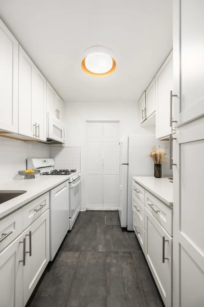 a kitchen with white cabinets appliances and sink