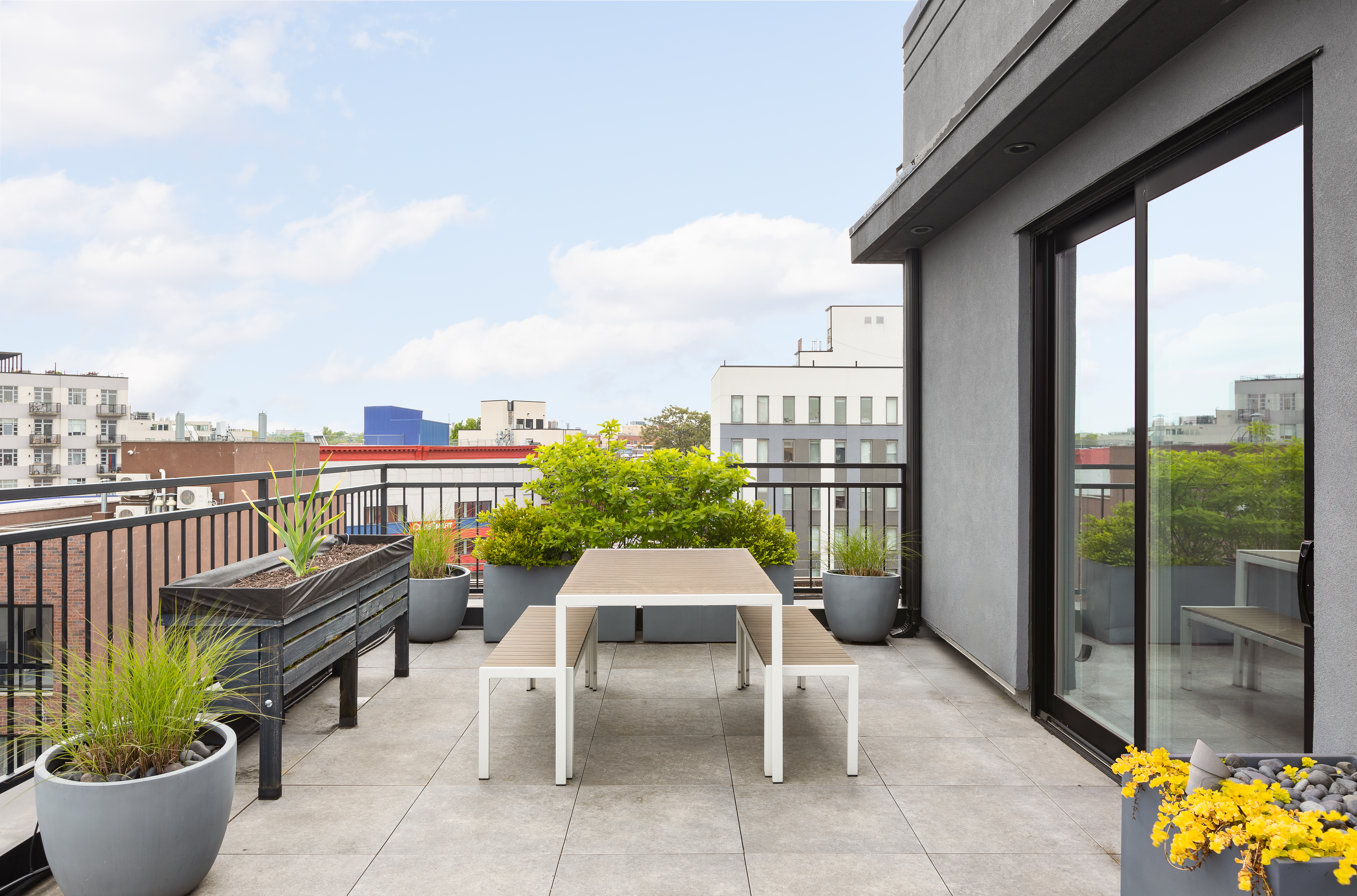 1122 Lafayette Avenue, Unit 4C Brooklyn, NY 11221 - Photo 6 of 14 a roof deck with a table and chairs and potted plants
