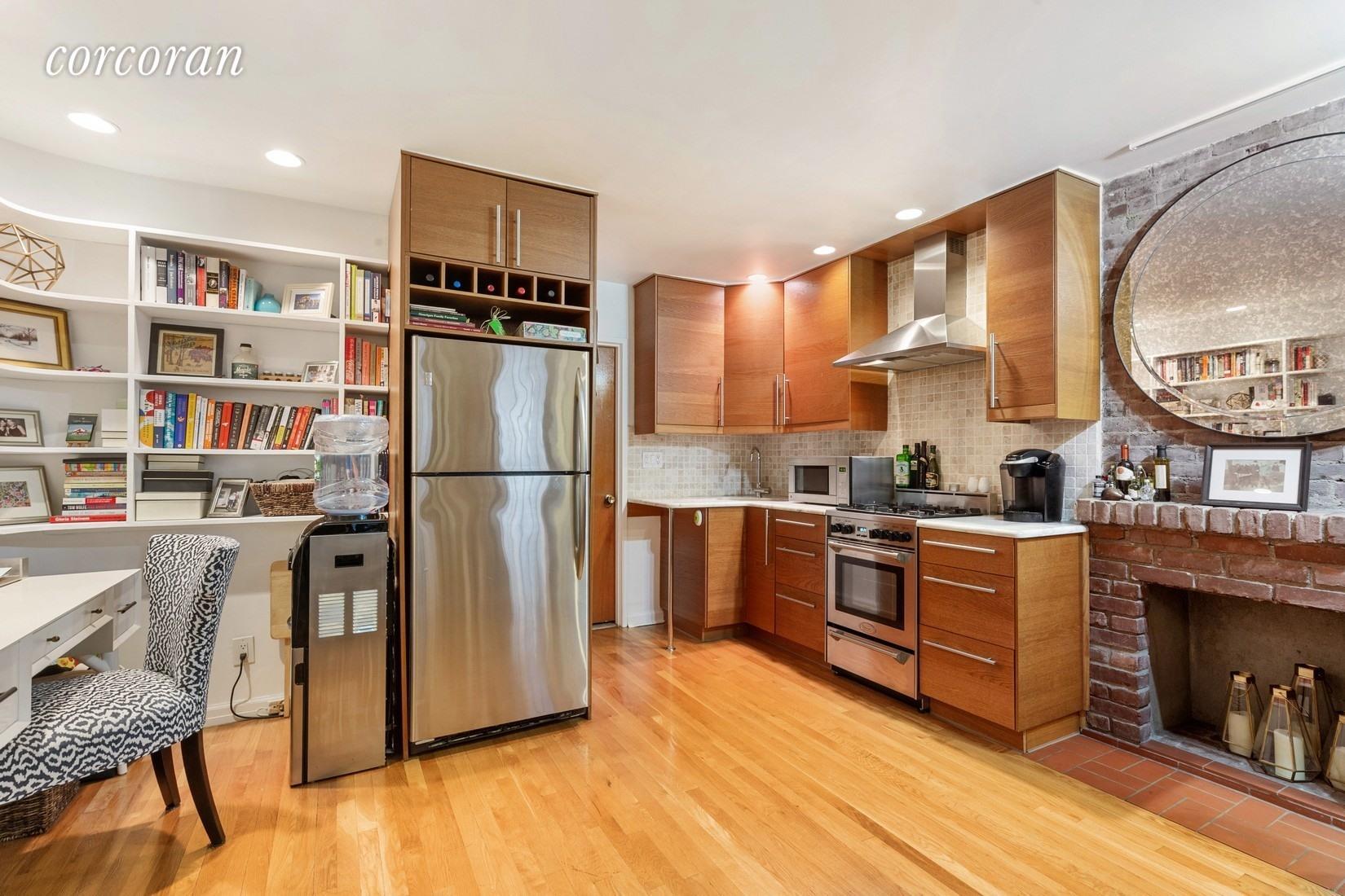 107 West 70th Street, Unit 1F Manhattan, NY 10023 - Photo 2 of 5 a kitchen with stainless steel appliances granite countertop a refrigerator a stove and a wooden floors