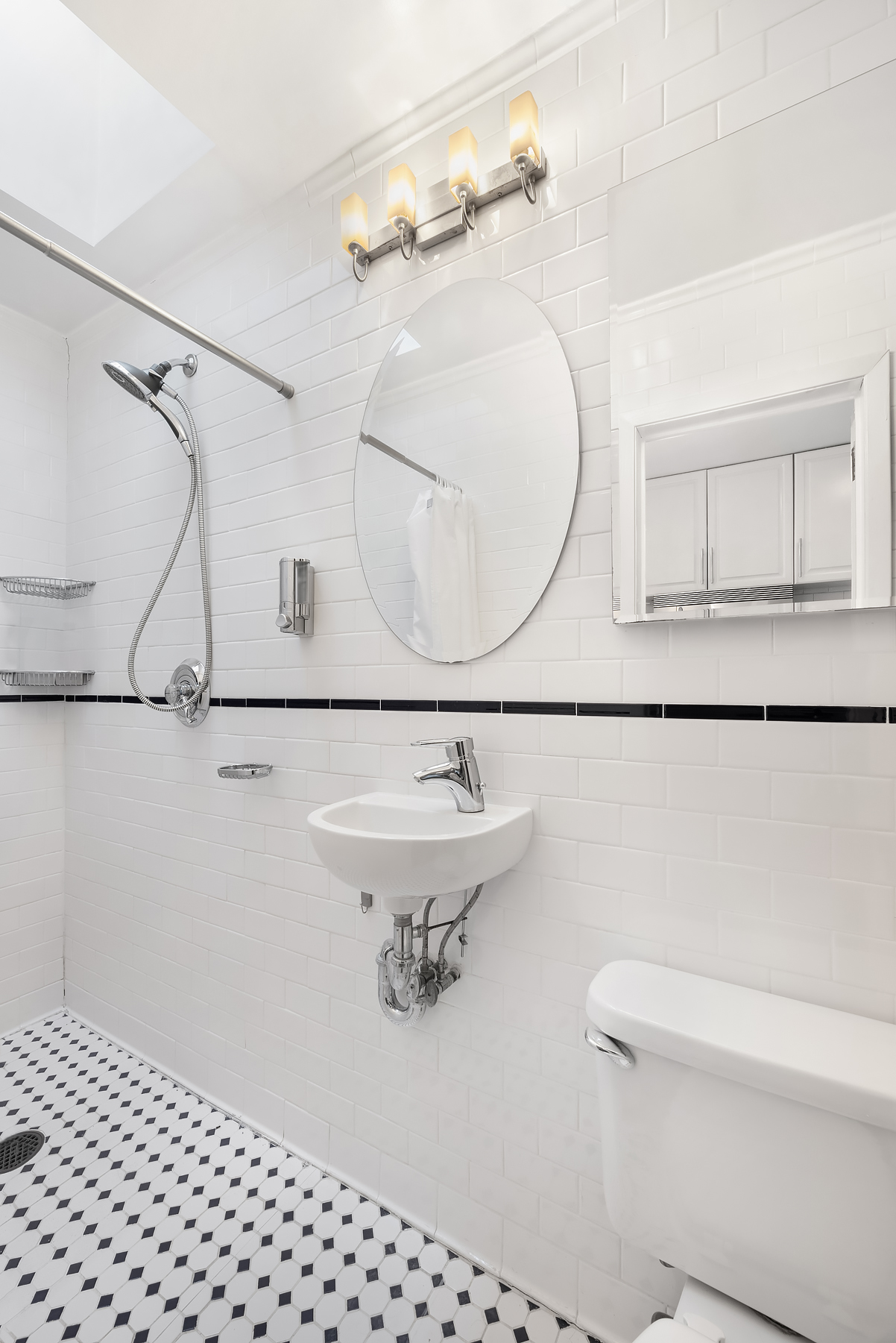 522 West 50th Street, Unit E3 Manhattan, NY 10019 - Photo 4 of 6 a bathroom with a sink a toilet and a mirror