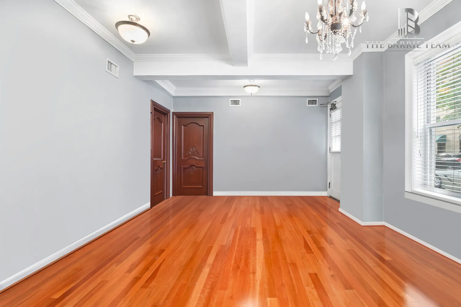 a view of empty room with wooden floor and fan
