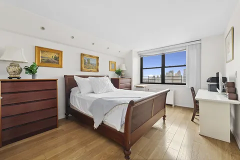 a large bedroom with a bed and a dresser in it