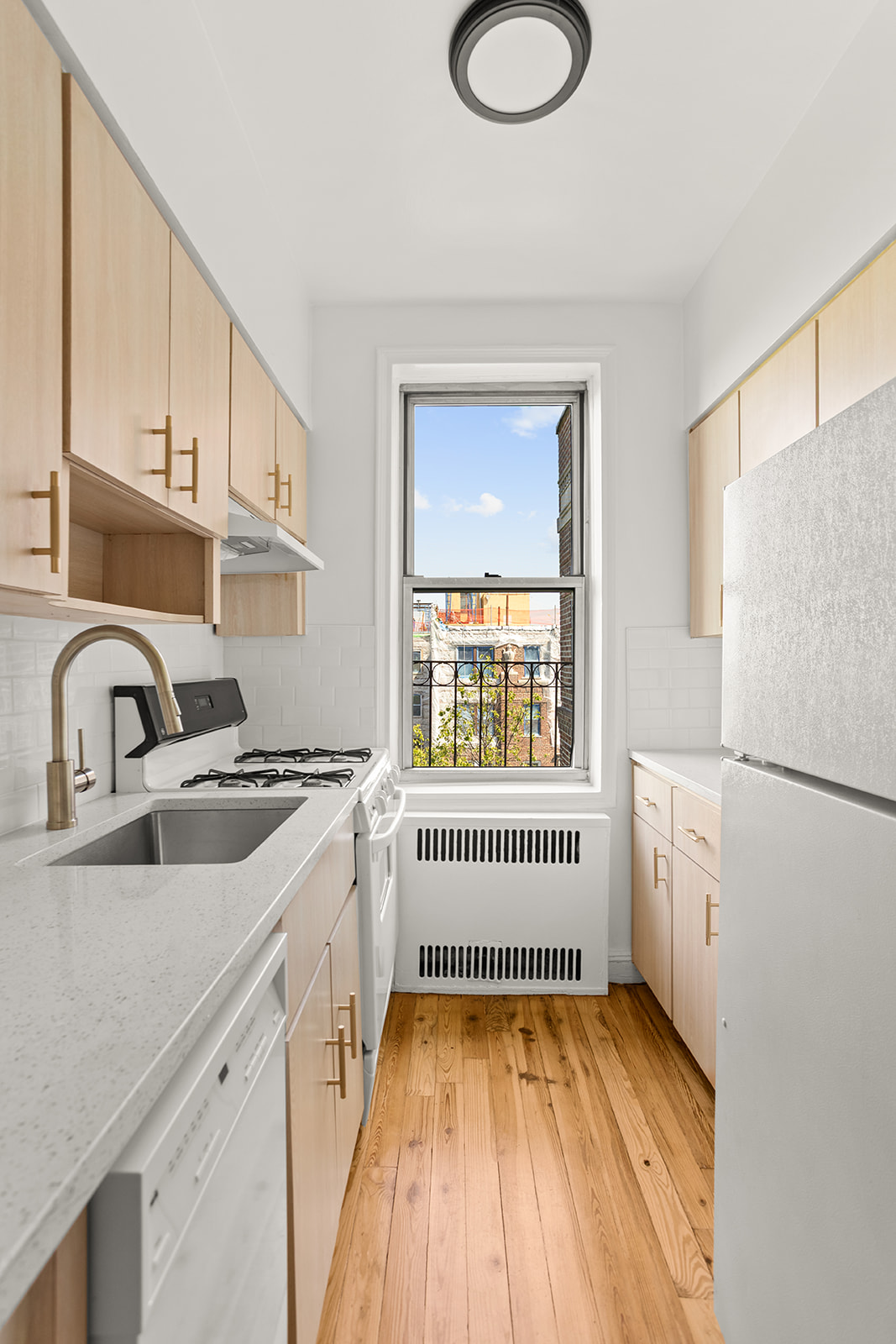 76-12 35th Avenue, Unit 6N Queens, NY 11372 - Photo 8 of 14 a kitchen with white cabinets and white appliances