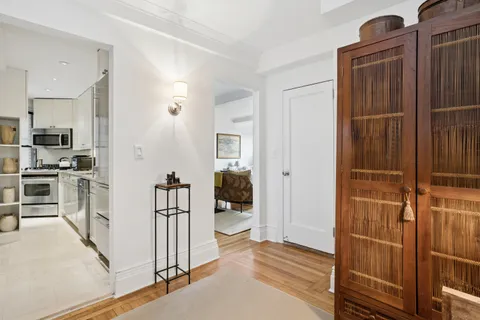a view of a hallway with wooden floor and windows
