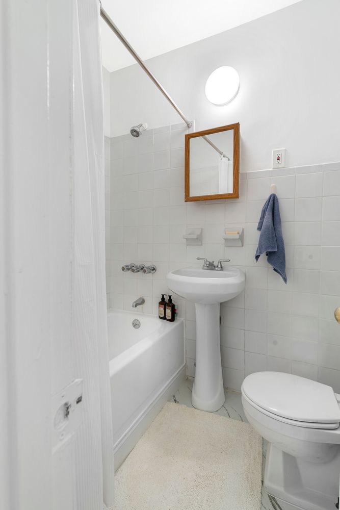 317 East 73rd Street, Unit 3FE Manhattan, NY 10021 - Photo 5 of 6 a bathroom view with a sink mirror and toilet